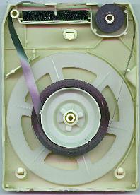 The inside of a cartridge. The black rubber pinch roller is at the upper right