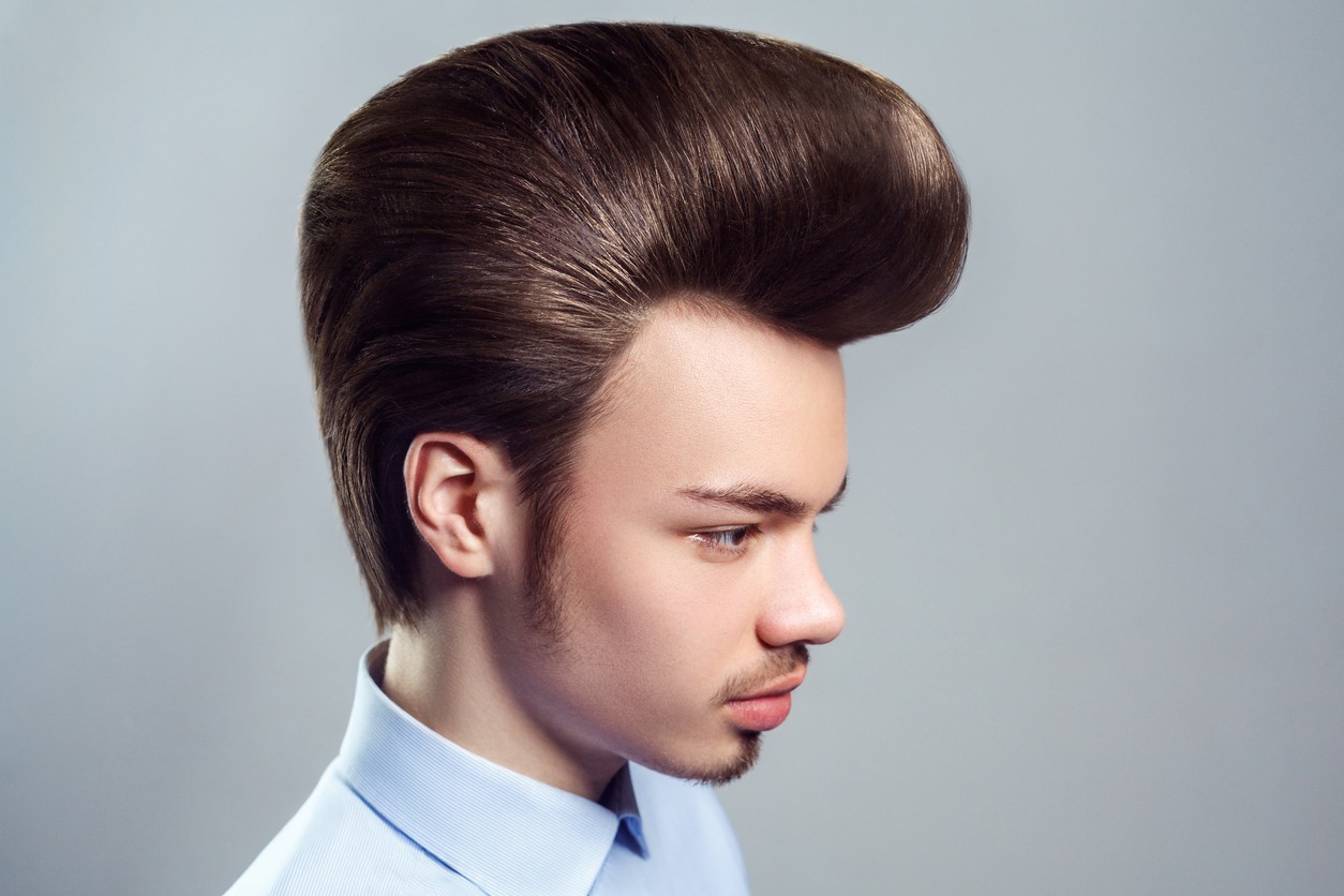 Side view portrait of young adult attractive man with mustache and beard with retro classic pompadour hairstyle