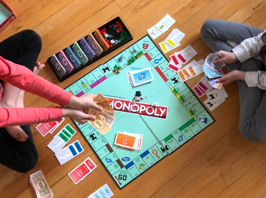 two girls playing Monopoly