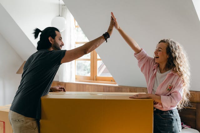 Couple high fiving after packing and discussing does success in music require relocation