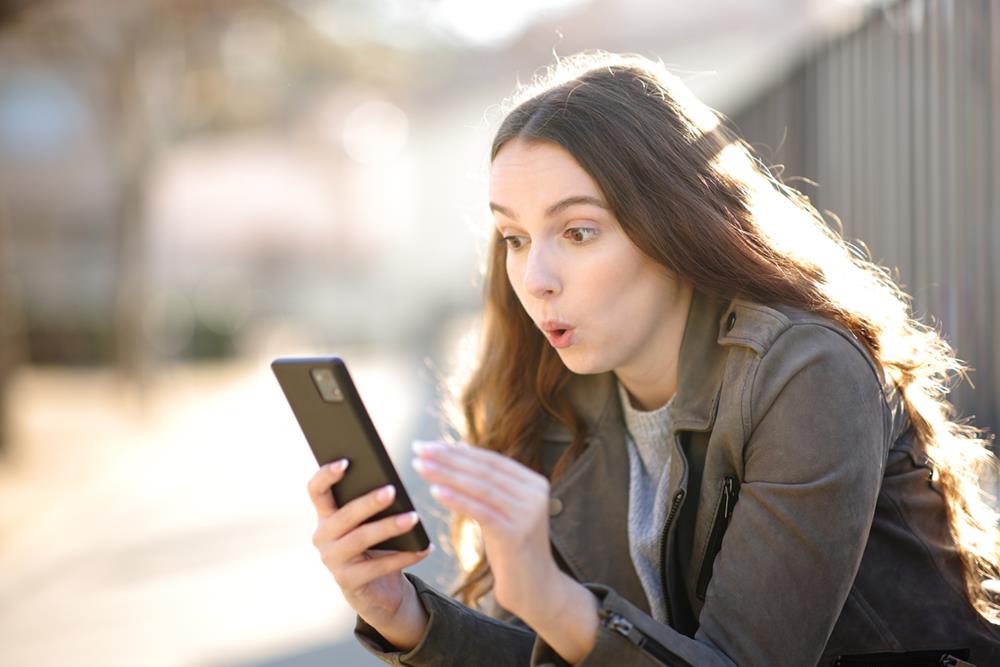 Woman looking surprised with what she saw on her phone