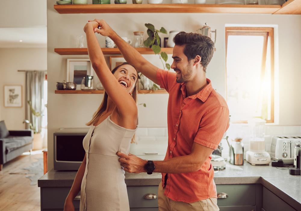 Shot of a young couple dancing together in their kitchen