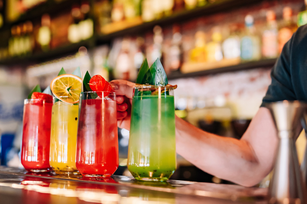Bartender making cocktail in glass on the bar counter
