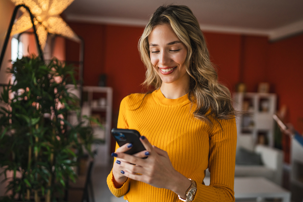High school blondie girl with use mobile phone at home stock