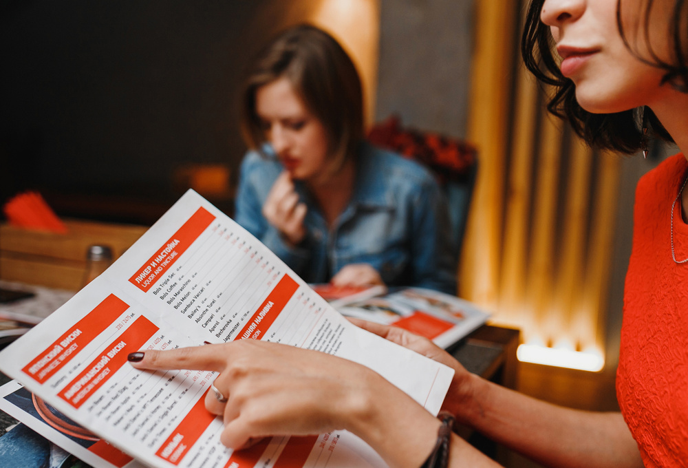 Girlfriends in cafe night club choose the food menu