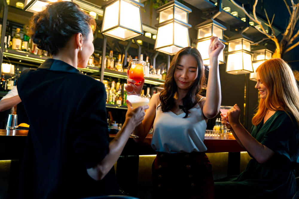 Group of Women friends celebrating holiday event dinner party hanging out drinking alcoholic cocktail at restaurant bar. Cheerful people enjoy and fun meeting nightlife celebration party at nightclub