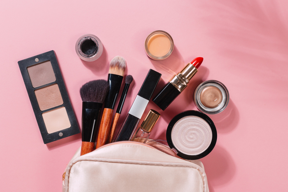 Set of decorative cosmetic powder, concealer, eye shadow brush, blush, foundation on pink background