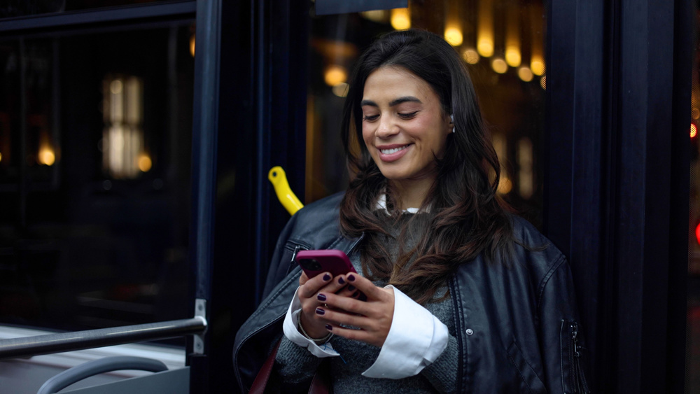 Young woman surfing the net during a night bus ride