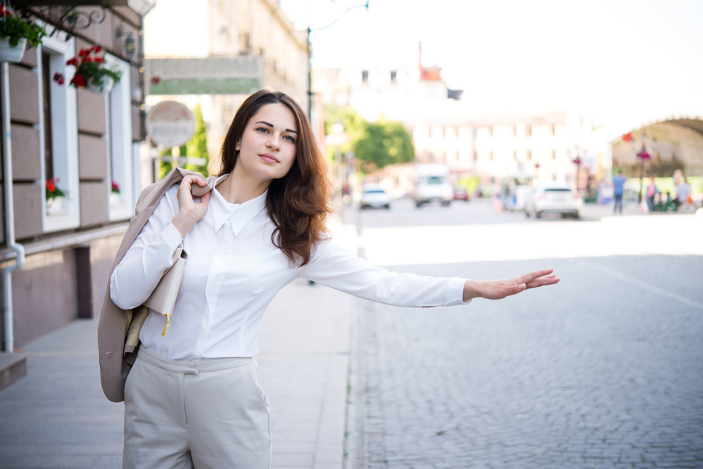 Business girl is trying to catch a taxi