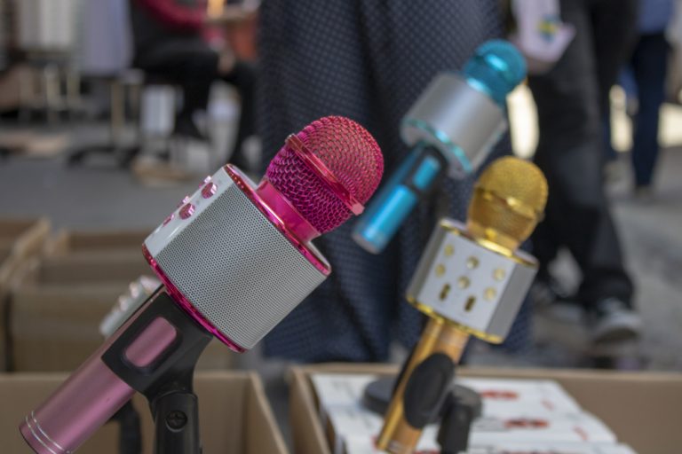 Karaoke microphone with feet. It has a loudspeaker on it. It was taken in front of the store