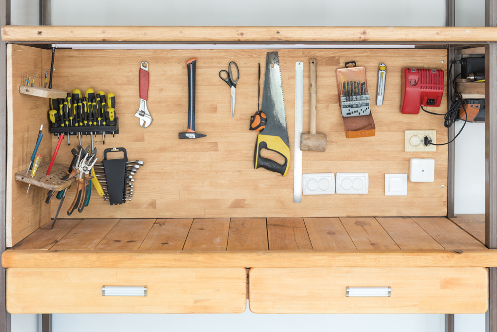 Wooden workbench at workshop. Lot of different tools for diy and repair works. Wood desk for product display. Copyspace. Labour day