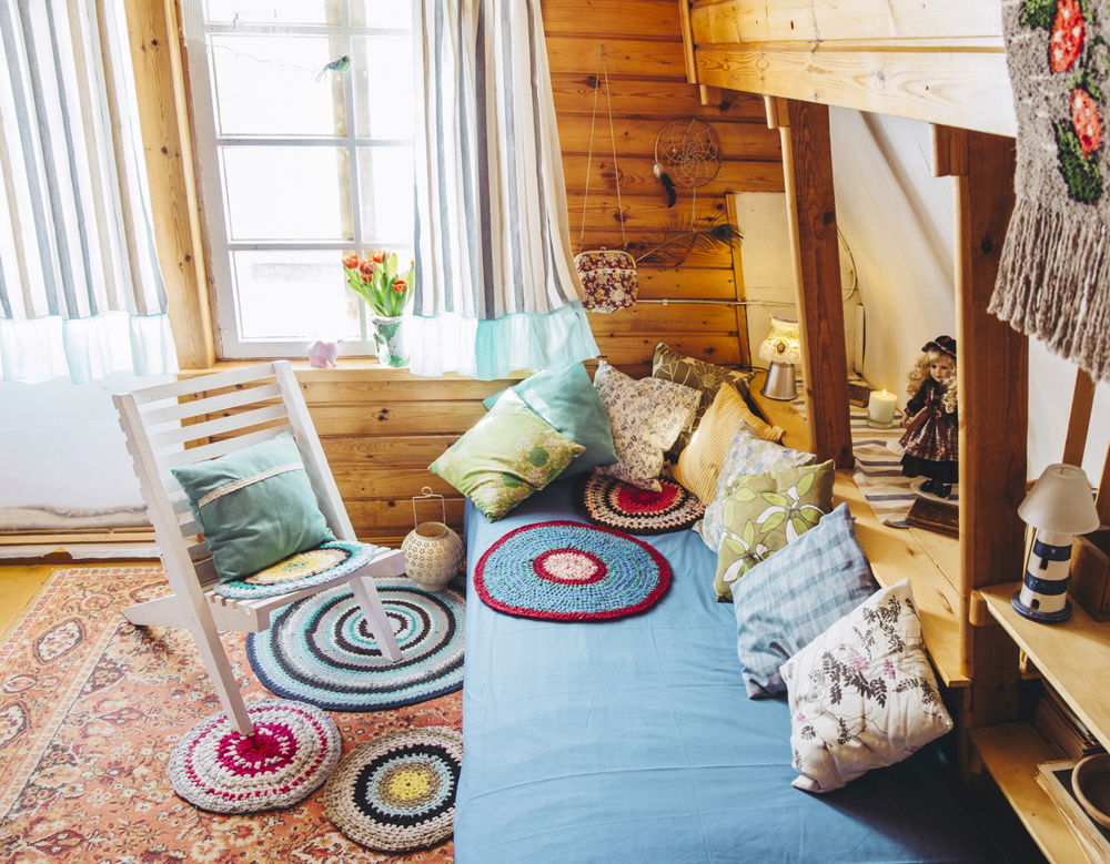 Maximalist home concept. Holiday home cabin bedroom with natural wooden board walls and ceiling and lot of different color details