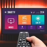 Man watching TV, remote control in hand. VOD service on TV
