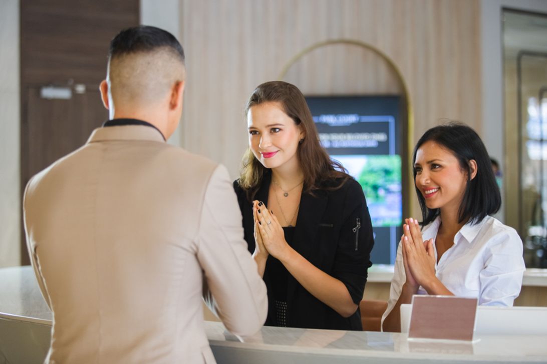 A foreign expat greeting locals with a wai as part of Thai customs and etiquette